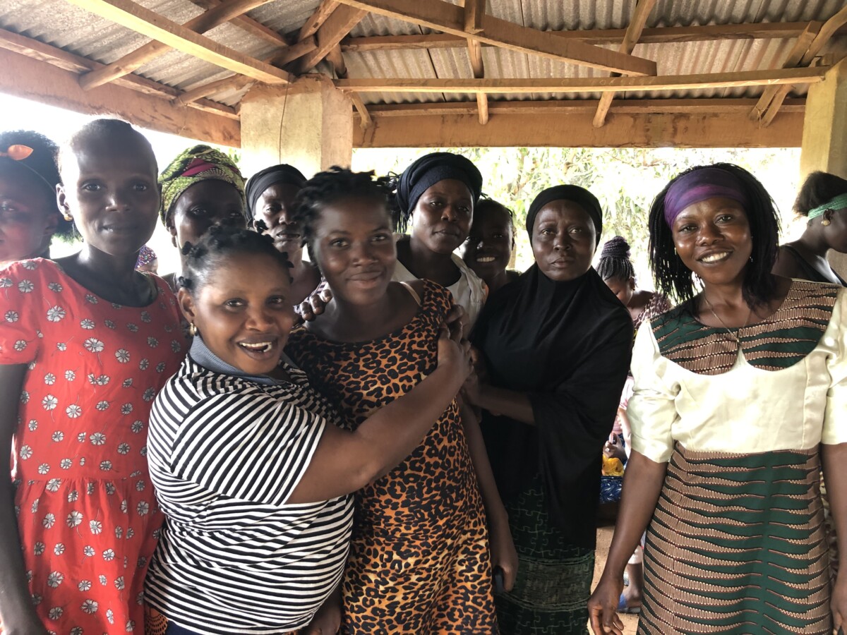 Literacy circle participants smile at the camera and hug each other.