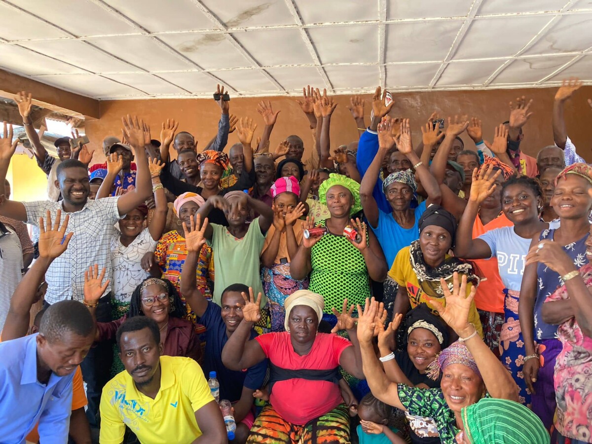 Group of people smiling and raising their hands.